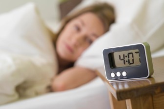 Wecker neben schlafender Frau