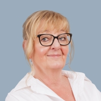 Portrait einer älteren Mitarbeiterin mit Brille