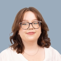 Portrait einer jungen Mitarbeiterin mit braunen Haaren und Brille