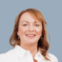 Portrait einer Mitarbeiterin mit dunkelblonden Haaren und Ohrringen
